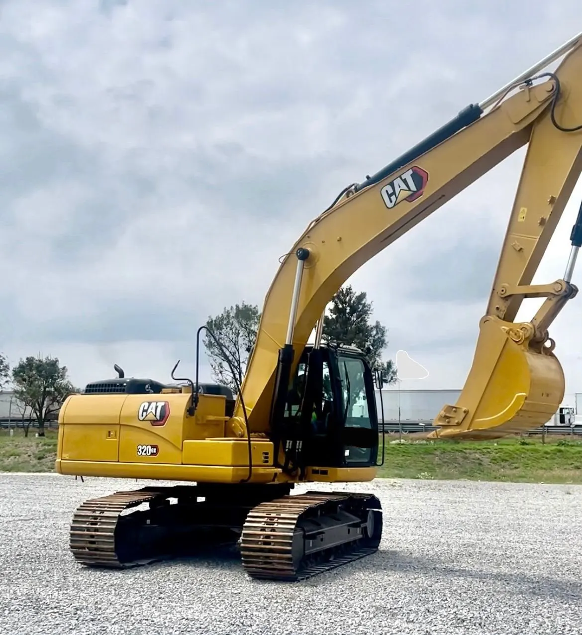 Excavadora de orugas CAT 320 GX con el brazo elevado.